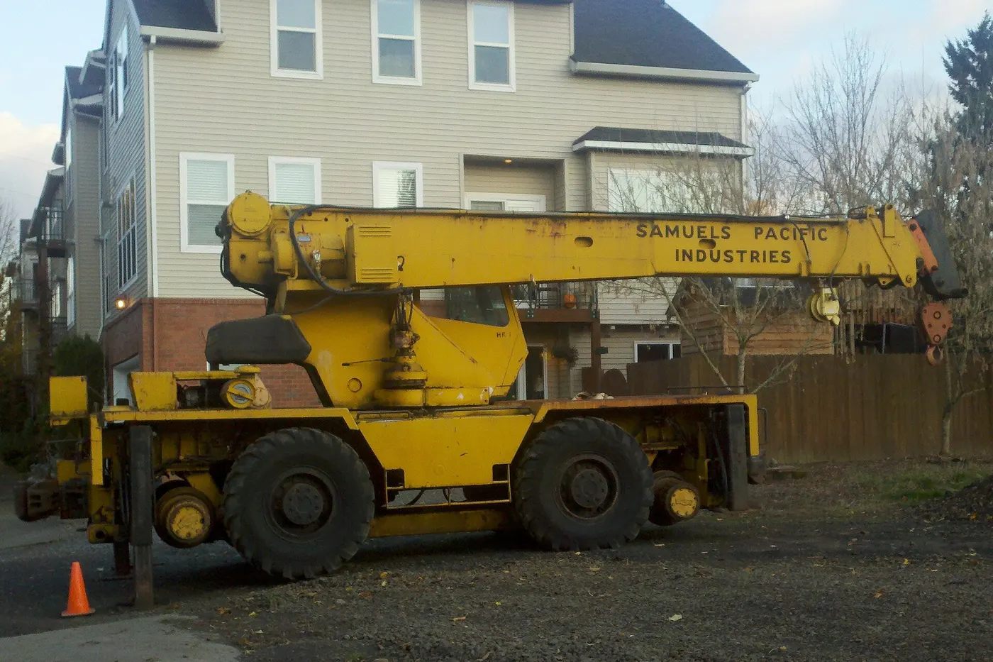 Yellow rough-terrain crane parked on a job site